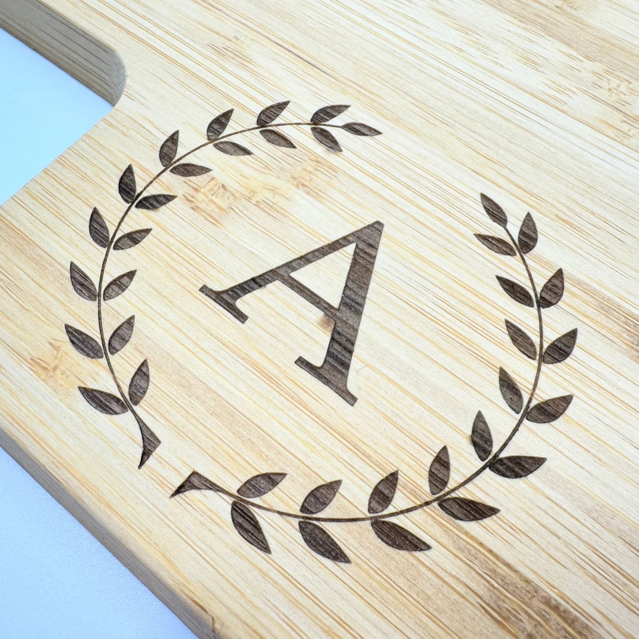 Personalized bamboo charcuterie board with engraved text and design, perfect for serving and gifting.