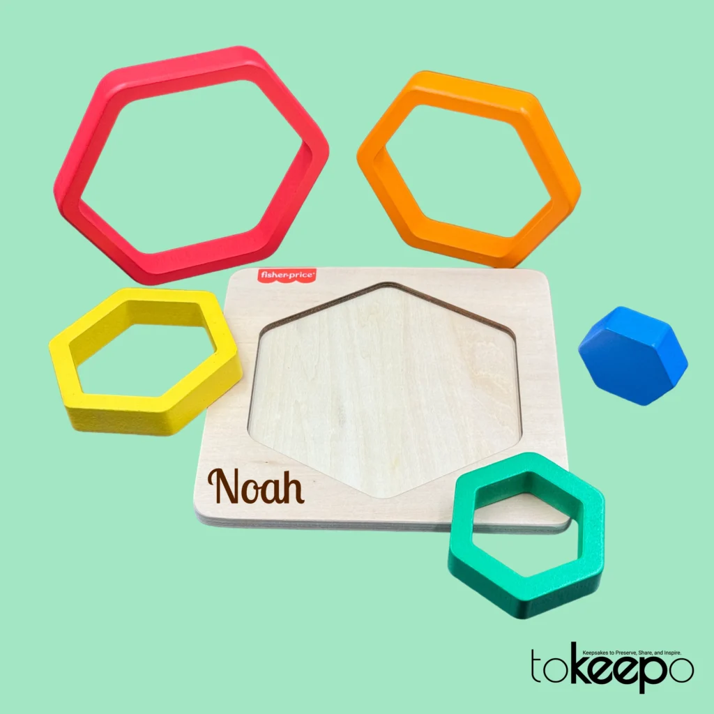 Fisher-Price® wooden hexagon puzzle for toddlers with colorful nesting layers, customizable with a name through tokeepo's personalization service.