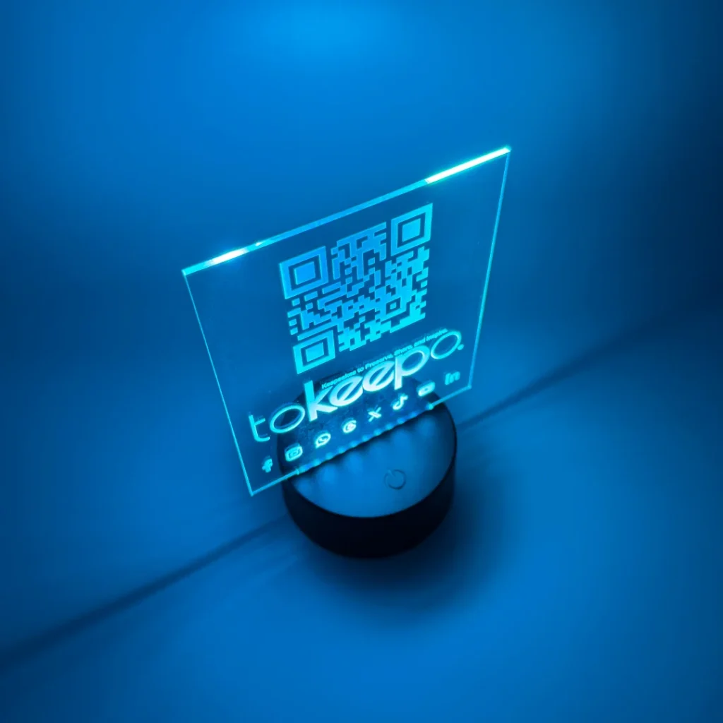 LED Acrylic Desk Lamp by tokeepo with a glowing acrylic plaque featuring engraved designs, including a QR code and logo, illuminated on a laser engraved transparent acrylic.
