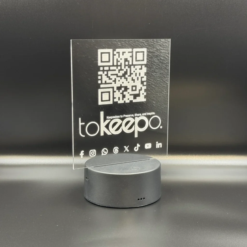 LED Acrylic Desk Lamp by tokeepo with a glowing acrylic plaque featuring engraved designs, including a QR code and logo, illuminated on a laser engraved transparent acrylic.