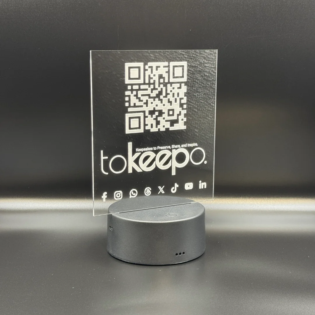 LED Acrylic Desk Lamp by tokeepo with a glowing acrylic plaque featuring engraved designs, including a QR code and logo, illuminated on a laser engraved transparent acrylic.