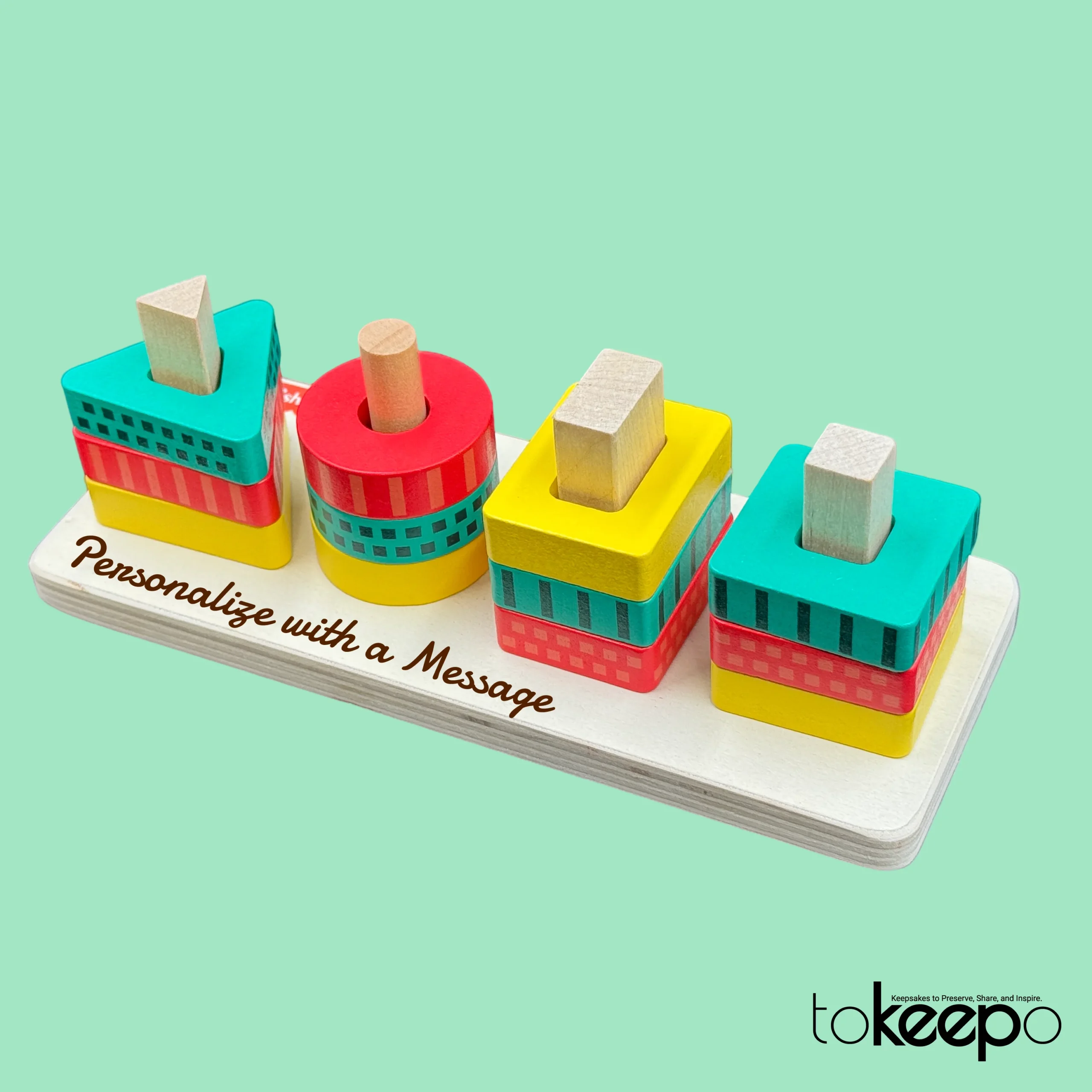 Personalized wooden stacking toy for toddlers, featuring colorful geometric shapes and an option to engrave a custom message on the base.