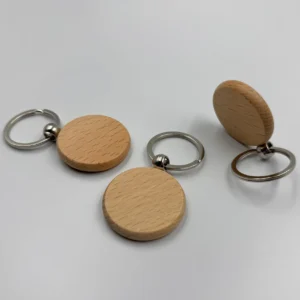 Round wooden keychains, attached to silver keyrings, placed on a white background.