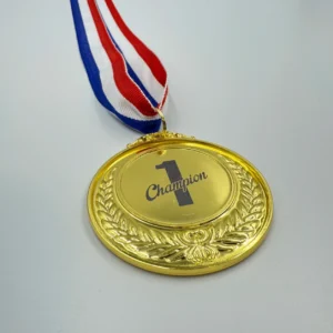 A gold medal with neck ribbon featuring a laurel wreath design, laser marked with the "Champion 1" logo in the center, hanging from a red, white, and blue ribbon.