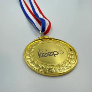 A gold medal with neck ribbon featuring a laurel wreath design, laser marked with the "tokeepo" logo in the center, hanging from a red, white, and blue ribbon.
