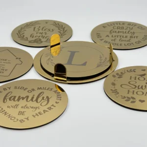 A gold stainless steel coaster set with an engraved family quote, neatly stacked in a matching holder.