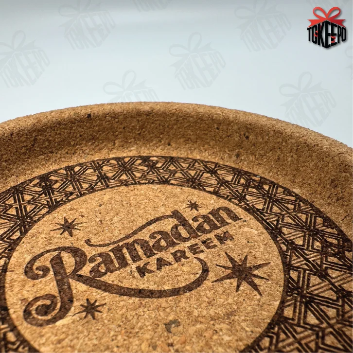 Close-up of cork coaster laser engraved with “Ramadan Kareem” and decorative stars and border pattern.