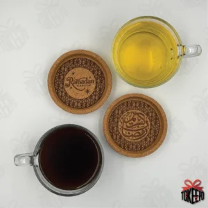 Set of two Ramadan cork coasters with different engravings, shown with tea and coffee mugs in a flat lay.