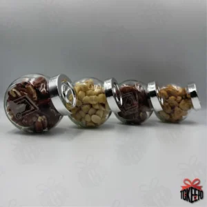 Four engraved glass reward jars with silver lids lined up on their sides, showing the complete set.