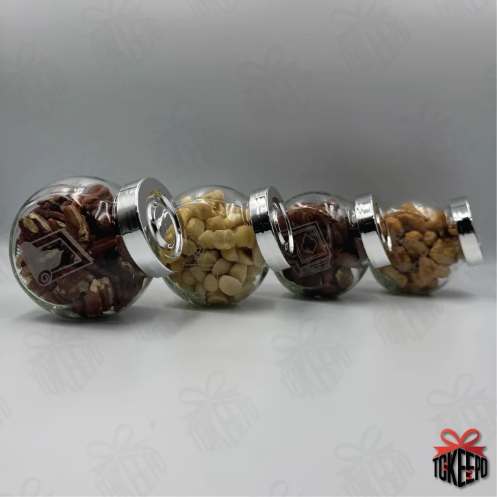 Four engraved glass reward jars with silver lids lined up on their sides, showing the complete set.
