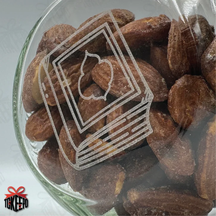 Close-up of engraved Quran reward jar filled with almonds, showing the frosted engraving on the glass.